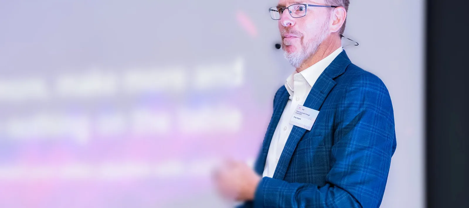Greg Adgate presenting on stage at a technology conference